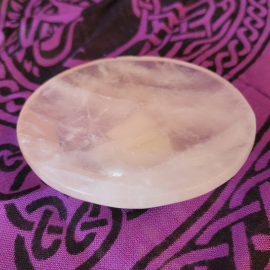 Rose quartz bowl dish on purple patterned fabric background