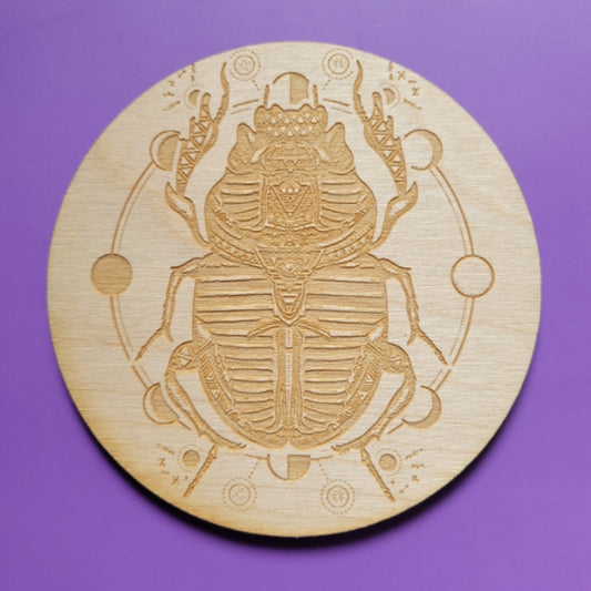 Scarab Beetle Crystal Grid wooden circle with engraved scarab design on purple background