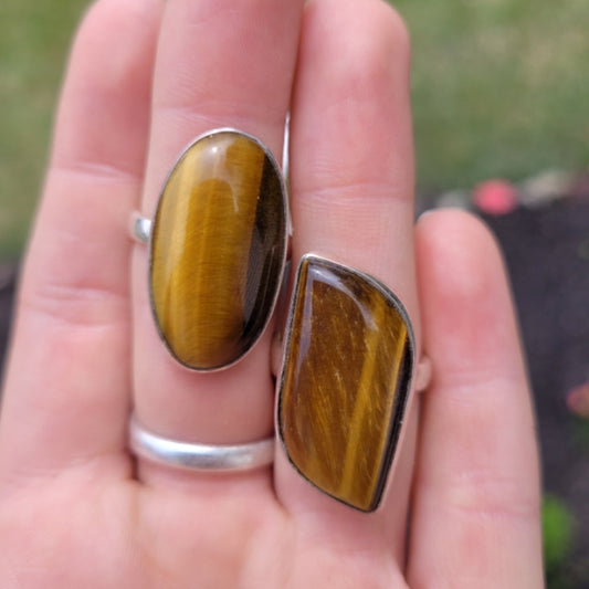 Adjustable rings featuring polished tiger eye stones with silver bands