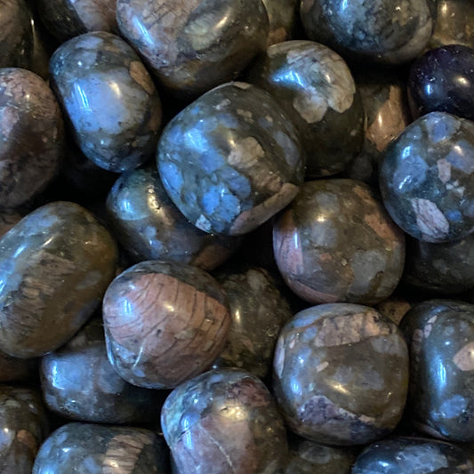 Close-up of smooth, polished Sera Tumble crystals with gray and pink hues promoting chakra balance and inner harmony
