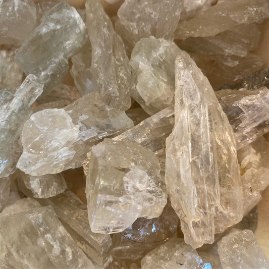 Clear raw Hiddenite tumbles stones with natural crystalline texture and irregular shapes