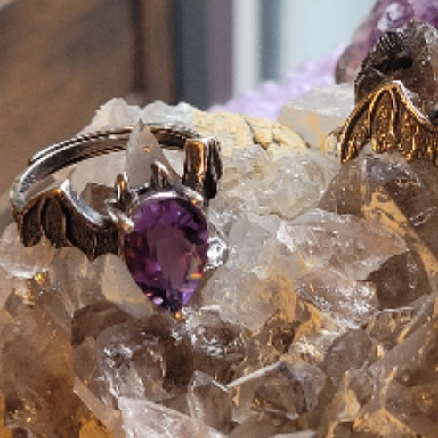 Ring Amethyst Bat with purple amethyst stone and bat wing design on crystal background