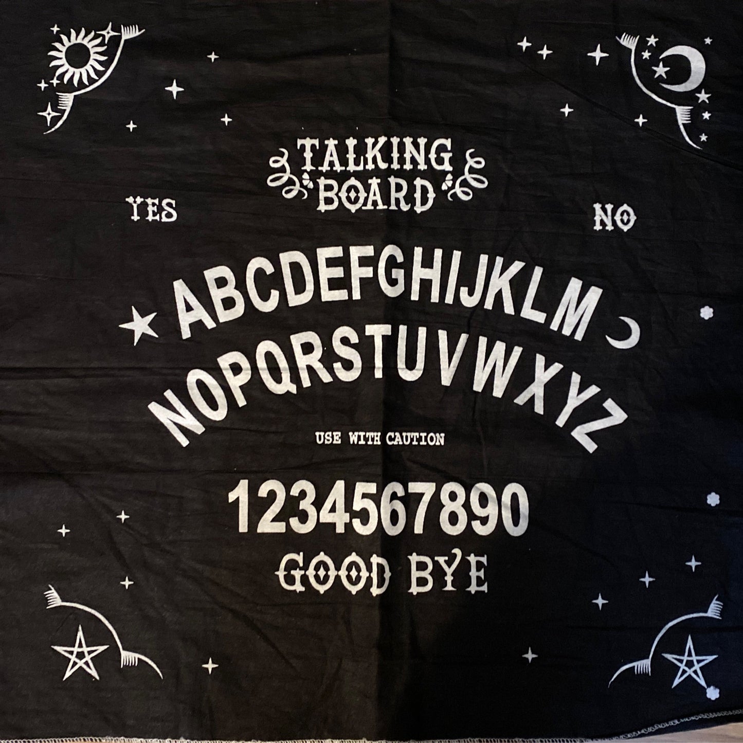 Black talking board altar cloth featuring alphabet, numbers, yes/no options, and mystical symbols