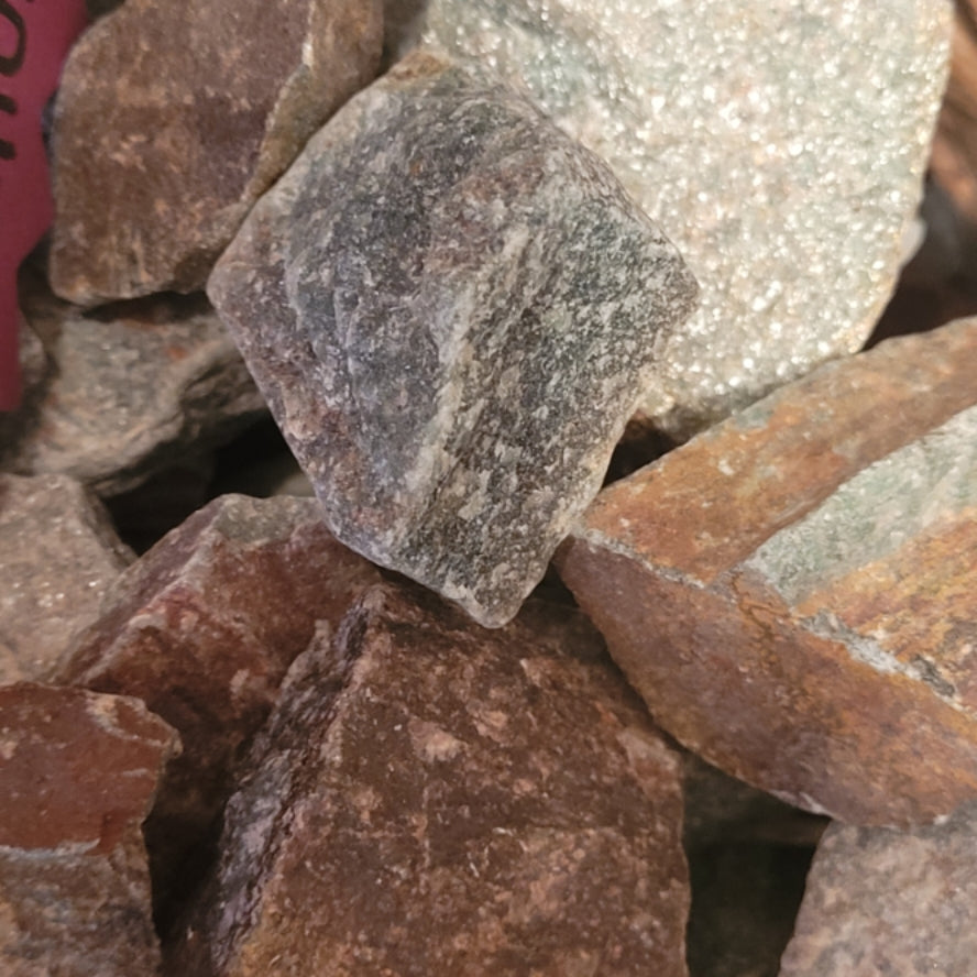 Raw green aventurine stones in natural rough form with mixed earthy tones