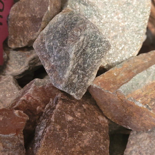 Raw green aventurine stones in natural rough form with mixed earthy tones