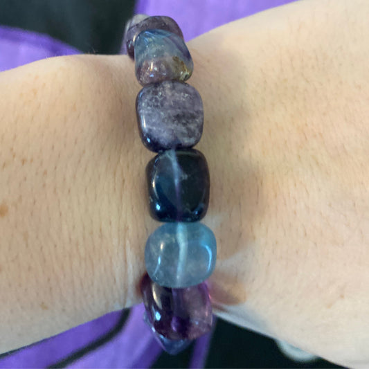 Close-up of a fluorite tumbled bracelet with polished multicolored stones on wrist
