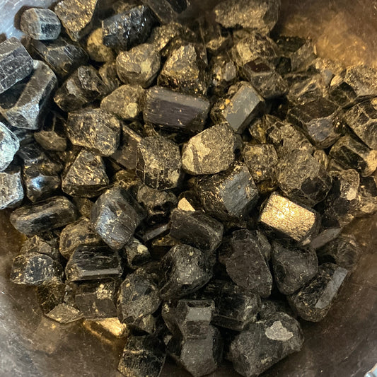 Close-up of raw black tourmaline tumble stones for grounding and protection