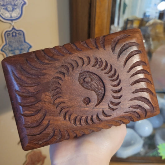 Handcrafted wooden Yin Yang Box with intricate carved design held in hand